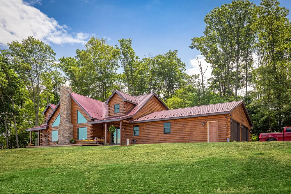 Log home with red standing-seam metal roof, photo 1