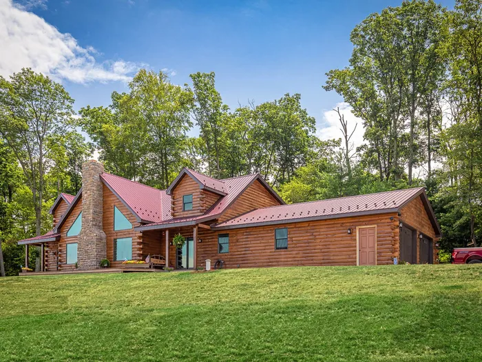 Log home with red standing-seam metal roof