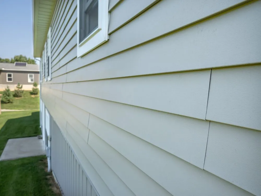 Close-up along a wall of lap siding, showing the shadow line each course casts on the one below